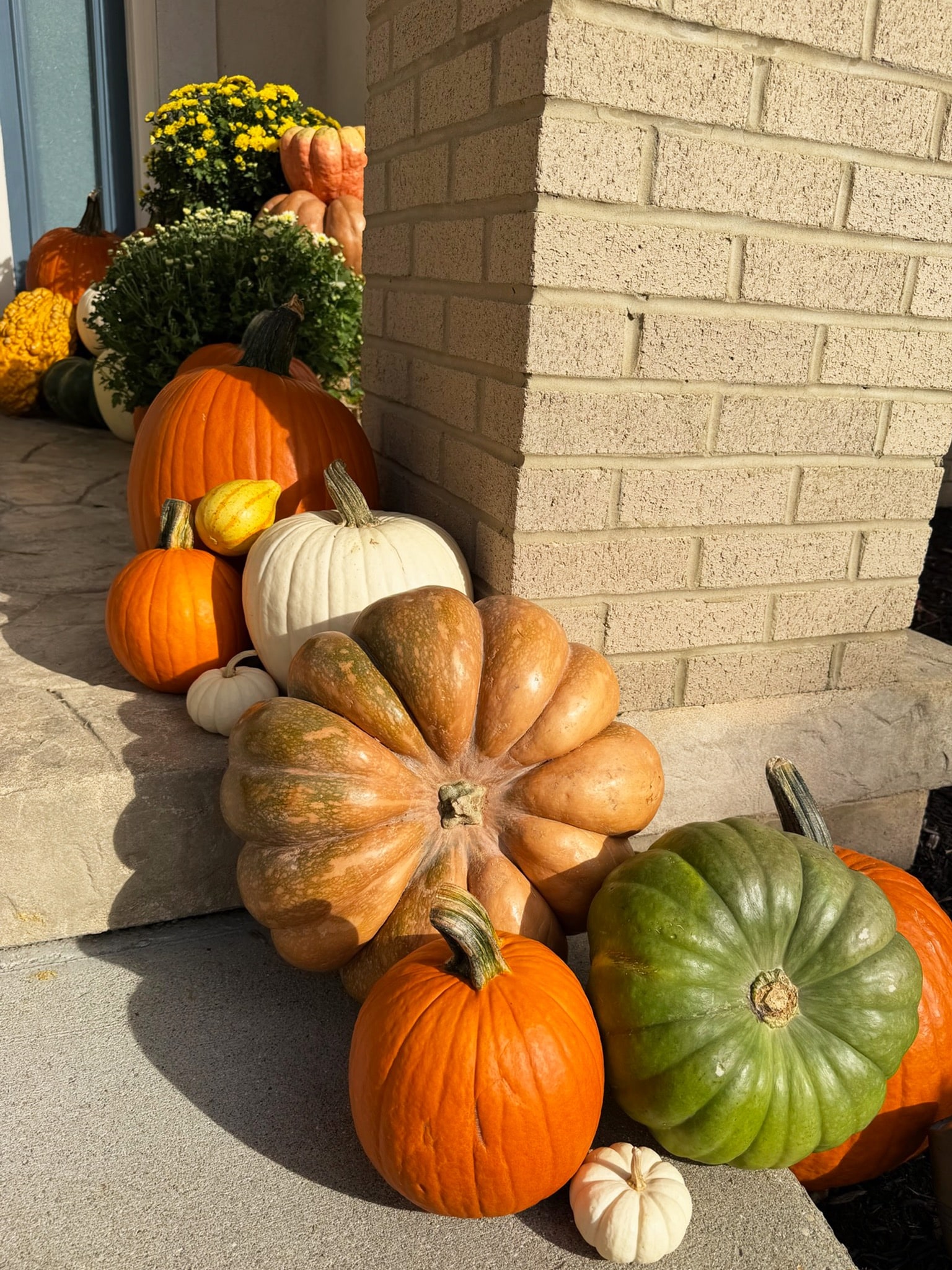 Heirloom pumpkins and gourds grouped around the right brick pillar